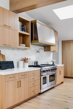 a kitchen with wooden cabinets and stainless steel stove top oven in the middle of it