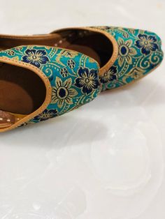 Green Brocade base with exotic spring flowers in shades of blue and golden colours!! Its subtle, yet elegant and is perfect for everyday casual look!! *Ethnic Shoes/Women Flats/Handmade Indian Designer Women Shoes or Slippers/Royal shoes/traditional style Women SPECIFICATIONS: *Upper/Panna -Green base with golden motifs and floral print *Back/Adda - Green base with golden motifs and floral print *Lining - Leather *Padding - Double Cushioning for extra comfort *Sole/Talla - Vegetable tanned leath Bohemian Flats With Zari Work, Bohemian Festive Flats With Round Toe, Bohemian Flats With Zari Work And Closed Toe, Bohemian Dori Work Flats With Round Toe, Bohemian Flats With Gota Work And Round Toe, Transitional Bohemian Flats, Bohemian Flats With Cutdana, Bohemian Flats With Zari Work And Round Toe, Bridal Shoes Green