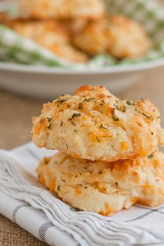 two biscuits stacked on top of each other in front of a plate with another biscuit