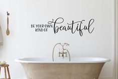 a bath tub sitting next to a wall with the words be your own kind of beautiful on it