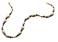 "We used genuine lapis beads to accent our handmade Egyptian scarab beads. The gold scarabs are pewter with high quality 18K gold plating. The back of the scarab beads are traditionally marked with hieroglyphic symbols. Both necklaces measure 18\" long and have a lobster claw closure. The earrings have a drop length of 1-3/4\". These pieces are shipped in a jewelry box with information card. The ancient Egyptians attached great religious significance to the combination of lapis and gold and to t Gold Beaded Necklace With Polished Beads, Traditional Gold Jewelry With Lapis Lazuli, Traditional Gold Lapis Lazuli Jewelry, Gold Lapis Lazuli Jewelry With Polished Beads, Gold Oval Beaded Necklace With Polished Beads, Gold Oval Polished Beaded Necklace, Gold Oval Polished Beads Necklace, Gold Hand-strung Amulet Necklace, Gold Amulet Style Necklace With Polished Beads