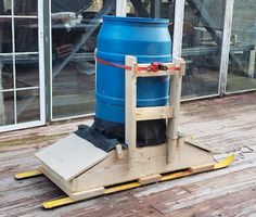 a large blue barrel sitting on top of a wooden pallet next to a building