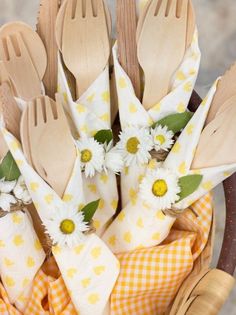 wooden utensils in a basket with daisies and gingham napkins