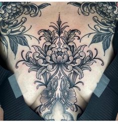 a woman's chest with an intricate tattoo design on her back and shoulder area