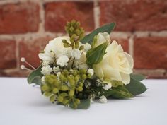 a bouquet of flowers sitting on top of a table next to a brick wall in the background