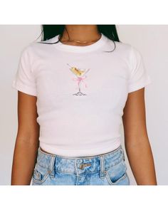 Martini Baby Tee   Women's T-Shirt | Girly Aesthetic | Y2K Trendy Shirt 🌟SHIRT This is a Bella+Canvas baby tee - the material is very soft and very high quality. 🌟SIZING Please find the size chart in listing photo before purchasing. We recommended measuring a t-shirt you already own to get the best fitting t-shirt. 💖CARE/ WASH Machine wash: warm (max 40C or 105F); Non-chlorine: bleach as needed Tumble dry: medium heat; Iron, steam or dry: low heat; Do not dry clean. ✨SHIPPING Your items usual Pink Fitted Graphic Tee, Fitted Basic T-shirt With Funny Print, Fitted Pink Graphic Tee Shirt, Cute White Short Sleeve Crop Top, Cute Fitted Summer T-shirt, Fitted Pink Cute T-shirt, Cute Fitted Pink T-shirt, Pink Fitted Cute T-shirt, Cute Fitted Cotton Shirt