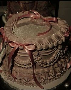 there is a large cake with pink ribbons on it