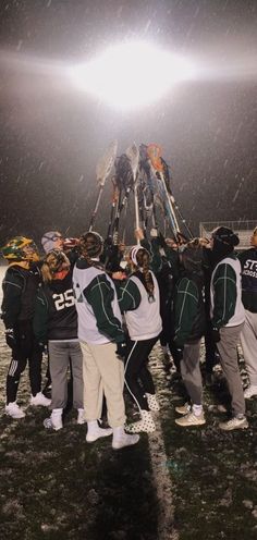 a group of young people standing around each other on top of a snow covered field