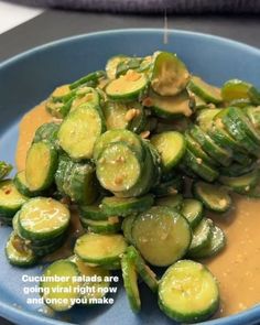 a blue plate topped with cucumbers and sauce