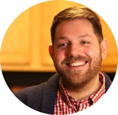 a man with a beard smiling at the camera