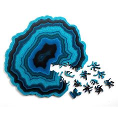 blue and black artwork on white background with small pieces of paper in the foreground