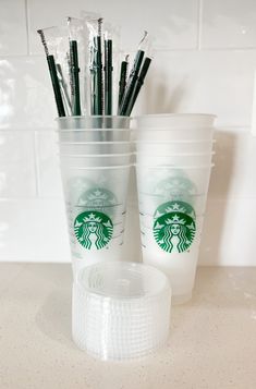 starbucks cups with straws in them sitting on a counter