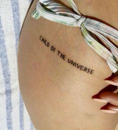 a woman's thigh with the words child of the universe written on her side