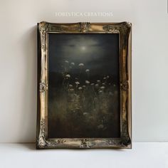 a painting hanging on the wall in front of a white wall with an ornate frame