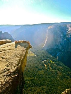 a person sitting on the edge of a cliff