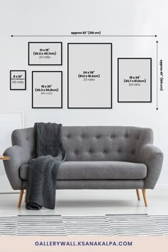 a gray couch sitting in front of a white wall with three pictures on the wall