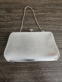 Vintage Silver Purse with Chain and rhinestone clasp.  Purse has black vinyl interior and used and shows a little wear on the one side (see pics), but in great condition.  Purse is approx 5 1/4 high 7 1/4 wide with chain it's 10 high. Please check pictures as they are a part of the description and feel free to contact me with any other questions prior to purchasing these items. Please review my shop policies below before checkout. Contact me if interested in more than one item or interested in international shipping.  I will combine shipping and send a quote. Check shop announcements for any active sales and promo codes.  If you require insurance, please be sure to contact me prior to ordering. (This will add $2 to your shipping cost.) Please note that priority mail already has insurance i Classic Silver Evening Bag For Formal Occasions, Classic Silver Evening Bag For Formal Events, Classic Chain Strap Evening Bag For Parties, Classic Evening Bag With Chain Strap For Parties, Classic Party Evening Bag With Chain Strap, Black Purse Silver Hardware, Black Evening Bag With Silver-tone Hardware, Cheap Black Vintage Coin Purse, Vintage Evening Bag With Turn-lock Closure