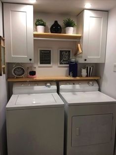 a washer and dryer in a small room with white cabinets on the wall