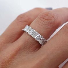 a woman's hand with a wedding band on it and an engagement ring in the middle