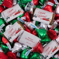 a pile of assorted candy wrapped in foil wrappers with merry holidays on them