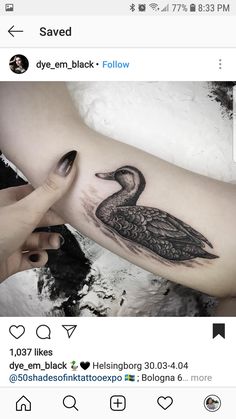 a woman's arm with a black and white duck tattoo on the left forearm