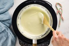 a person stirring cream in a blender with candy canes