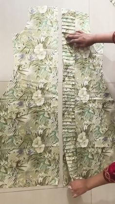 a woman is working on an art project with flowers and leaves printed on the wall