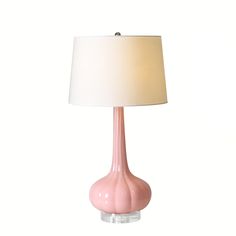 a pink table lamp with a white shade on the base and a light bulb attached to it