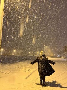 a woman walking in the snow at night