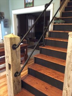 a wooden stair case with metal handrails in a living room