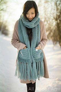 a woman standing in the snow wearing a scarf