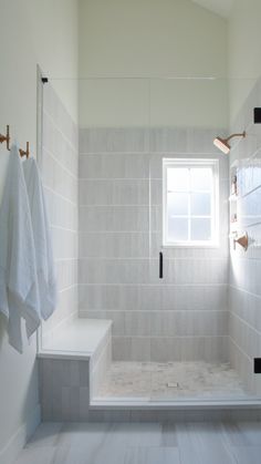 a bathroom with white tile walls and floor