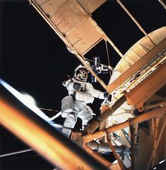 an astronaut standing on top of a metal structure