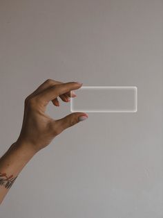 a woman's hand holding up a rectangular plastic object