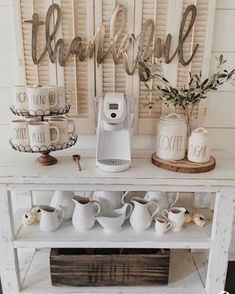 a white table topped with coffee cups and vases