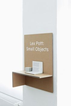 an open book shelf with a small object on it's left side, attached to the wall