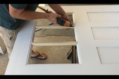 a man is painting the bottom part of a door with paintbrushes and glue