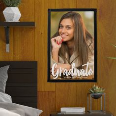 a bedroom with a bed and a poster on the wall that says graduate in front of it