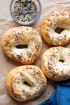 four bagels with poppy seed sprinkles and a bowl of seasoning