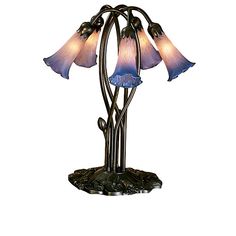 a lamp that is sitting on top of a metal stand with three flowers in it