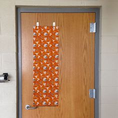 the door is decorated with an orange and white flowered scarf hanging on it's side