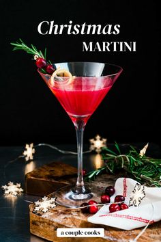 a christmas martini with cranberry and rosemary garnish