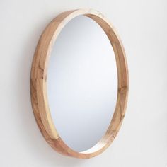 a round wooden mirror hanging on the wall