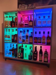 an illuminated liquor cabinet filled with lots of bottles