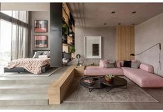 a living room filled with furniture and a large window next to a stair leading up to a bed