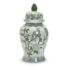 a white and green vase with flowers on the lid is sitting in front of a white background