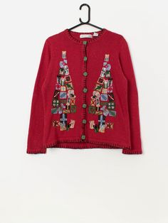 Vintage Christmas tree cardigan with appliqué present trees. This stunning red cardigan features a Christmas present tree pattern on the front, amazing gift patterned buttons, black piping and a crew neck. Made from a mid-weight wool blend. Our recommended size: Medium Label says: Medium Condition: Very good Material: 55% ramie, 15% wool, 15% acrylic, 15% nylon Measurements in inches: Pit to pit: 19 Shoulders: 15.5 Front length: 24 Back length: 25 Sleeve length: 24 Hem: 20 We recommend that you Long Sleeve Christmas Cardigan, Festive Long Sleeve Christmas Cardigan, Fitted Winter Cardigan For Festive Occasions, Fitted Cardigan For Winter Festivals, Red Embroidered Winter Cardigan, Embroidered Red Cardigan For Fall, Red Embroidered Fall Cardigan, Red Christmas Outerwear, Red Christmas Festive Outerwear