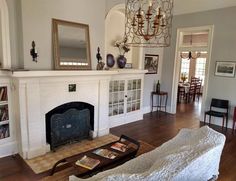 a living room filled with furniture and a fire place in the middle of a room