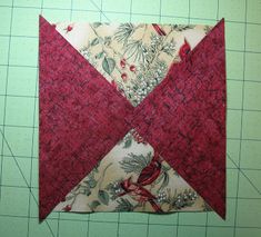 a red and white quilted piece of fabric on top of a green cutting board