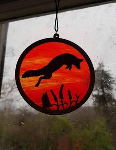 a window sill with an orange and black silhouette of a leaping animal